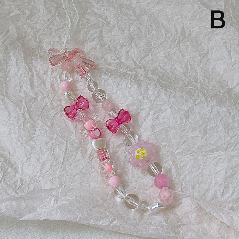 Sweet strawberry flower beaded phone strap charm with pink and green beads, featuring a charming pendant for women and girls.