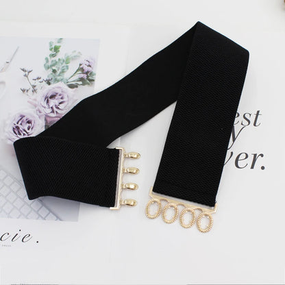 Women's wide elastic waist belt with metal buckle, corset style cinch belt, stylish clothing accessory for fashionable outfits.