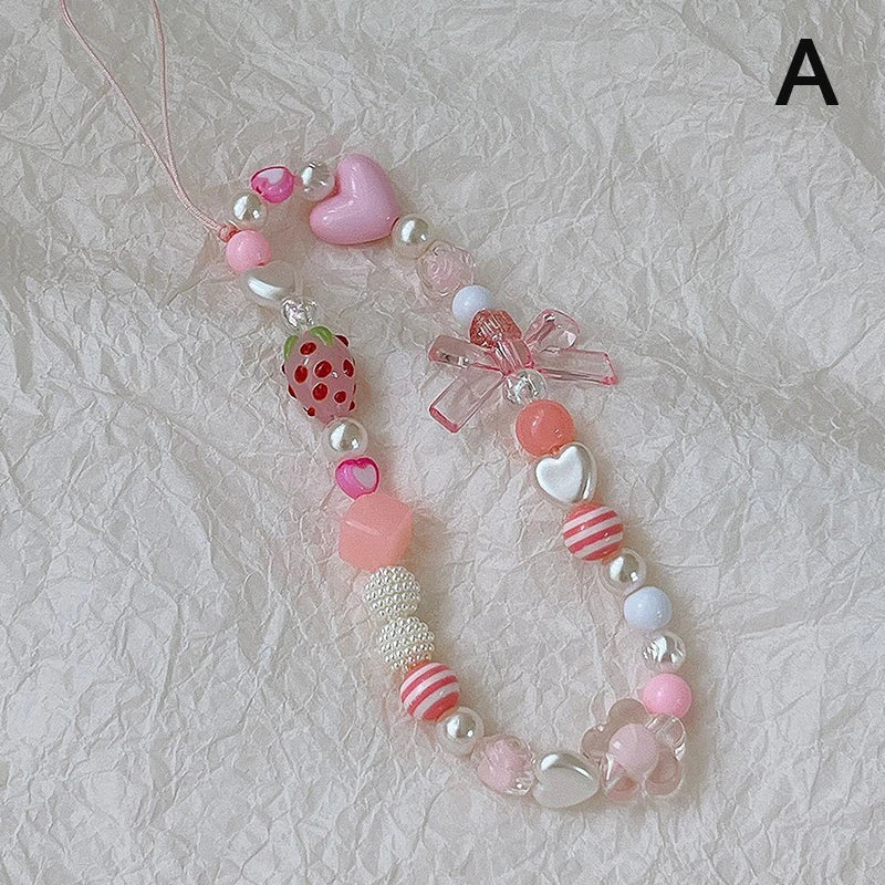 Sweet strawberry flower bead phone strap charm with pink beads and a small strawberry, attached to a cellphone lanyard for women